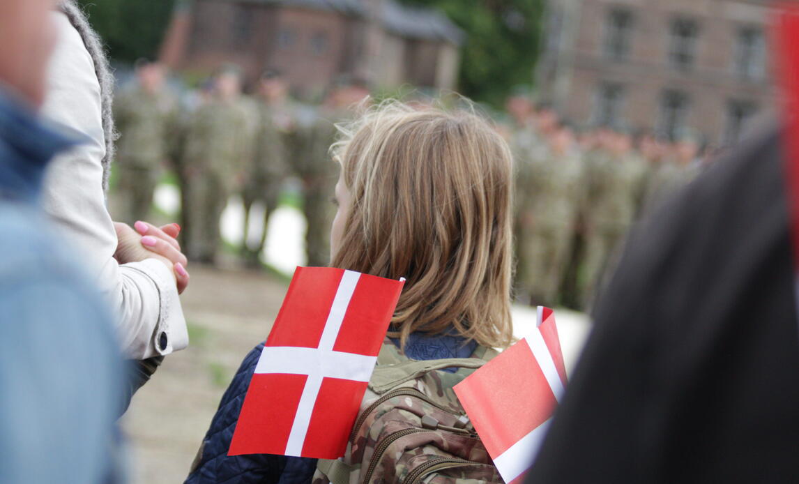Pige med flag foran soldater til Flagdag