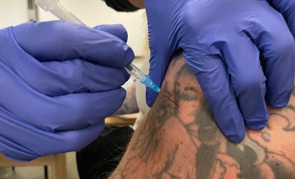 Veteran modtager sprøjte med Covid-19 vaccine i sin arm.