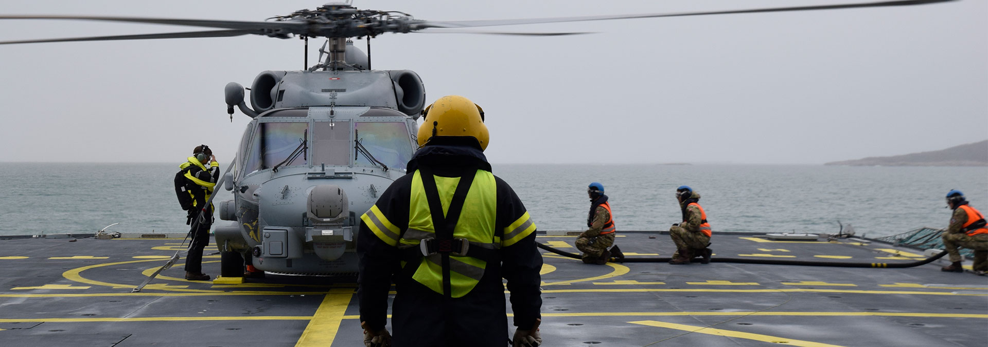 En Seahawk helikopter er netop landet på fregatten Willemoes' dæk med guide fra personel.