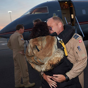 Pilot og partner kysser og omfavner hinanden foran en Challenger.