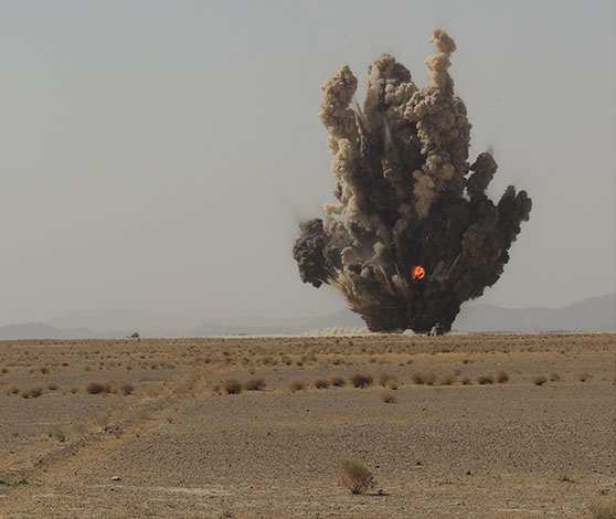 En eksplosion af sort røg med ildkugle i ørkenen.